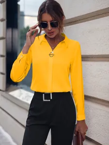 Vista detallada de una blusa amarilla de manga larga para mujer de estilo profesional.