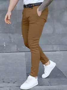 Detailed side view of men's slim fit brown casual trousers styled with white sneakers.