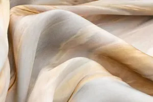 Gros plan détaillé montrant la texture douce et le motif tie-dye du tissu en satin.
