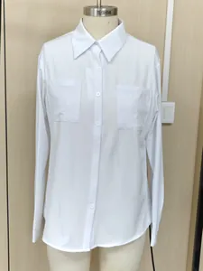 Vista frontal de una camisa blanca de manga larga con dos bolsillos en el pecho sobre maniquí