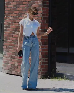 Stylish white short-sleeved cropped top with large flap pockets shown in outdoor setting