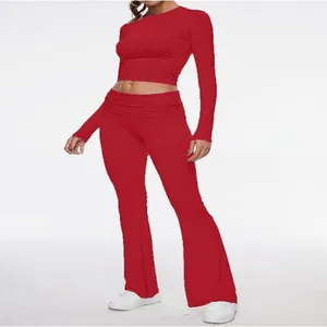 Detailed view of women's red long-sleeved crop top and flared leggings two-piece set