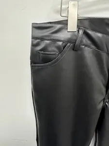 Detailed macro view of black PU leather pants showing waist structure and texture
