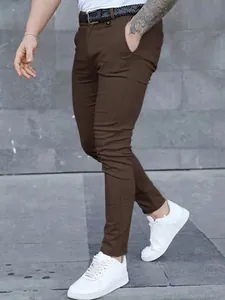 Detail shot of brown slim-fit men's casual trousers featuring a sleek tapered leg design