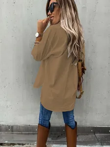 Detailed back view of a loose brown long-sleeved collared shirt worn by a woman.