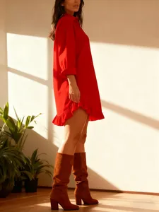 Detail view of a vibrant red long-sleeve shirt dress with elegant ruffle hem detail.