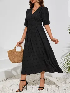 Detailed view of elegant black Swiss dot midi dress featuring a stylish V-neck design