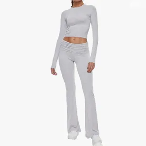 Women's heather grey two-piece yoga set with long sleeve crop top and flared leggings