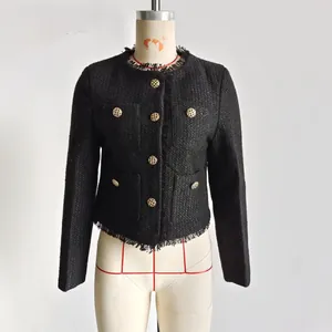 Detailaufnahme einer schwarzen Tweed-Jacke mit Glitzerfäden und goldenen Knöpfen
