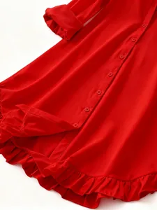 Close-up detail of a vibrant red long sleeve shirt dress with a ruffled hem and buttons.