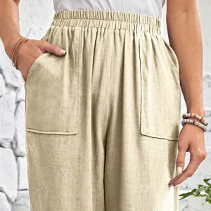 Detail view of women's beige cotton linen pants with large pockets and elastic waist.