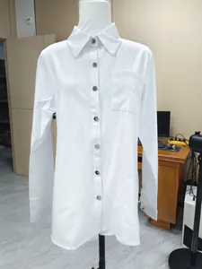 Front view detail of a white long-sleeved lapel shirt featuring silver metal buttons