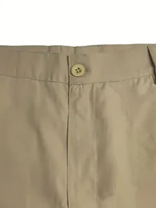 Close-up detail of khaki men's casual shorts showing waist button and fabric texture.