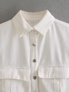High-quality close-up detail of a white denim jacket with silver buttons and collar tag.