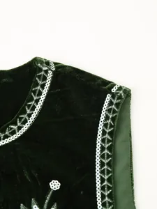 Dettaglio gilet in velluto verde scuro con paillettes argento e ricami bianchi.