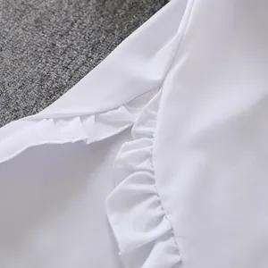 Detail view showing the elegant white ruffle edge craftsmanship on a casual blouse