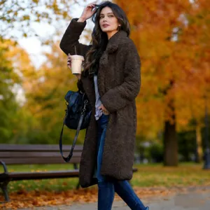 Full-length view of a women's brown teddy fleece coat in an autumn park setting