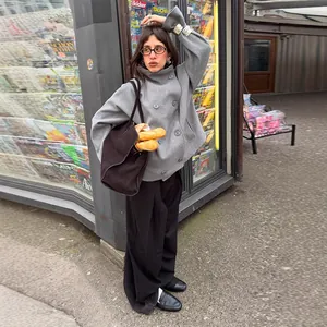 Street style view of a grey double-breasted coat with stand collar and neutral vibe