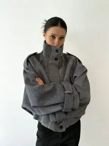 Detailed view of grey wool coat with high stand collar and single-breasted closure