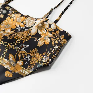 Detailed macro view of the vintage floral and gold chain print on black satin fabric