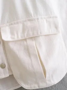 Close-up of a large utility pocket on a white denim cropped jacket vest.