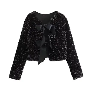 Detail view of black sequined cropped jacket with elegant satin bow front closures.