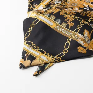 Close-up view showing the intricate retro chain and floral print on black satin fabric.