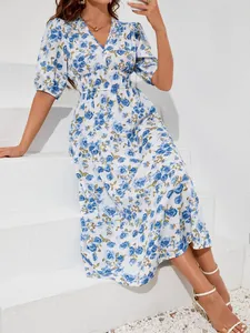 Elegant blue floral print midi dress detail with puff sleeves and cinched waistline.