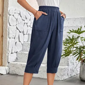 Close-up showing the navy blue cotton-linen texture and large pockets of women's pants