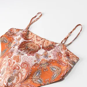 Close-up detail of vintage paisley print and adjustable straps on orange satin camisole