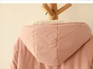 Detailed macro view showing the soft white fleece lining inside a pink hooded winter jacket