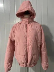 Vue de face d'une doudoune d'hiver rose à capuche sur un mannequin de vitrine