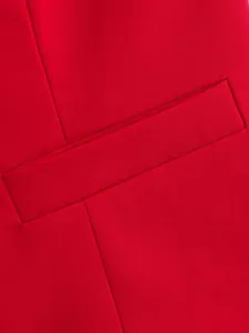 Vue rapprochée des coutures fines et du détail de la poche d'un gilet de costume rouge.