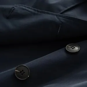 Macro detail of high-quality navy trench coat buttons and textured twill fabric