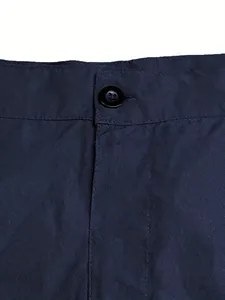 Close-up detail of navy blue cotton twill fabric and button on men's casual shorts