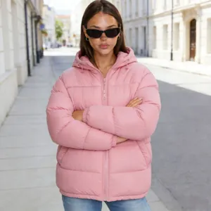 Détail d'une doudoune rose à capuche élégante sur un mannequin dans une rue urbaine