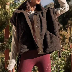 Detail view showing the warm texture and snap buttons of a brown sherpa fleece vest