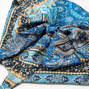 Close-up macro shot of vintage blue paisley print satin halter top showing fabric texture.
