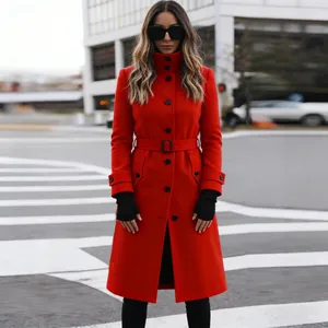 Detalle de un abrigo de lana rojo con cinturón y botones negros en estilo urbano chic.