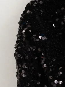 Macro view of black sequin texture showing the shimmering detail of a party jacket