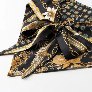 Detailed view of retro floral and golden chain print satin fabric tied in a delicate bow
