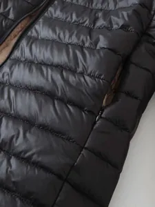 Detalle de cerca de chaqueta acolchada negra para mujer con forro de lana de cordero