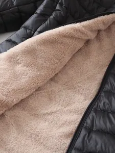 Detalle del cálido forro de lana sherpa beige dentro de la chaqueta de invierno acolchada negra