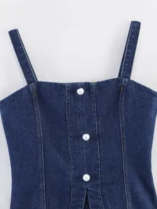Détail du débardeur en denim avec boutons perlés montrant la texture et les coutures.