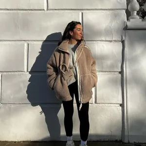 Lifestyle view of a cozy beige sherpa fleece jacket for women on a white background