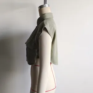Side detail of a sage green sleeveless cropped polo shirt with large utility pocket
