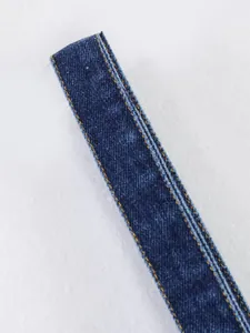Vue macro détaillée d'une bretelle en jean bleu avec coutures orange pour gilet femme