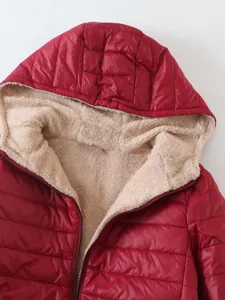 Detalle del suave forro polar beige en el interior de la chaqueta roja con capucha