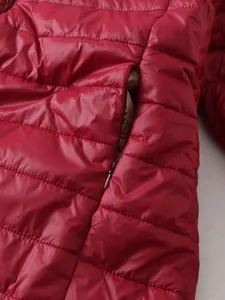 Detalle de cerca de la textura acolchada y el bolsillo con cremallera de la chaqueta roja