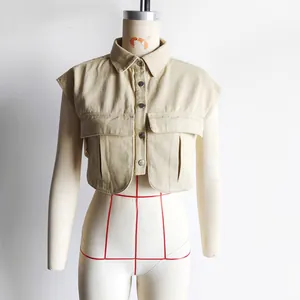 Close-up detail of a beige sleeveless polo collar faux denim shirt with large pockets.